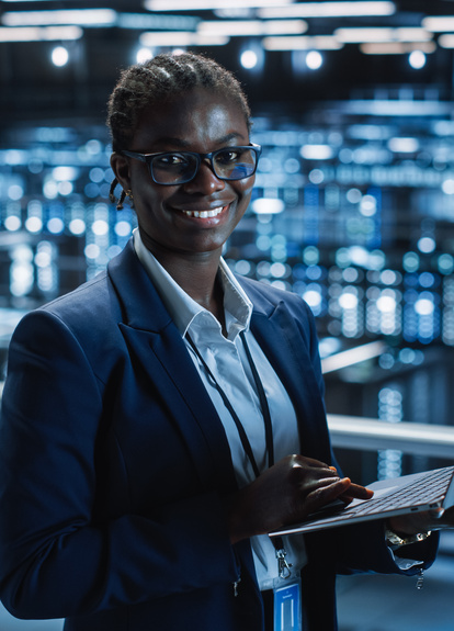 IT Professional Working on a Laptop in a Data Center