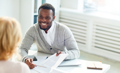 Smiling Professional Sharing a Document During a Meeting